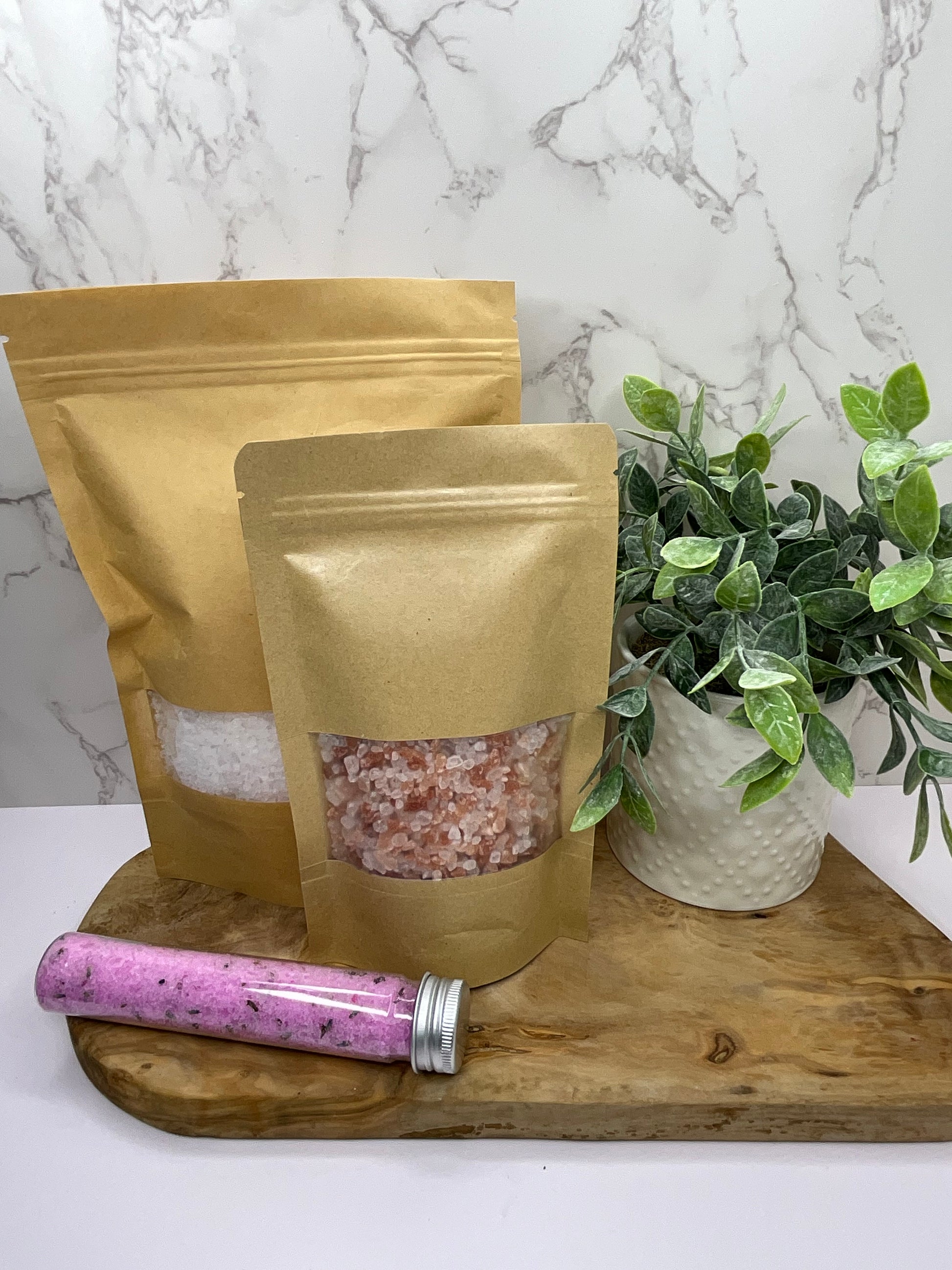 Three sizes of energizing bath salt soak: single-use tube, medium bag, and large bag, perfect for a refreshing and invigorating bath experience.